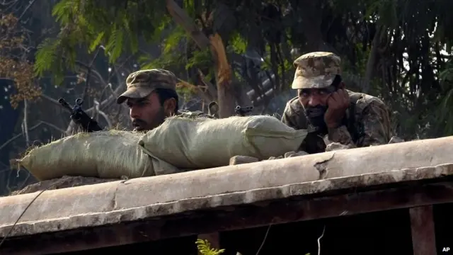 Pakistani troops are positioned close to a school during the attack by Taliban gunmen in Peshawar (16 December 2014)