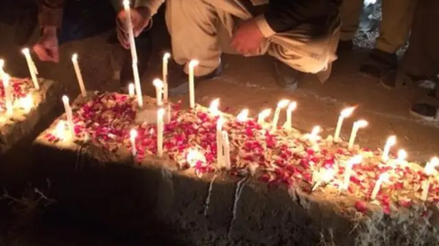 Coffins covered in candles and rose petals