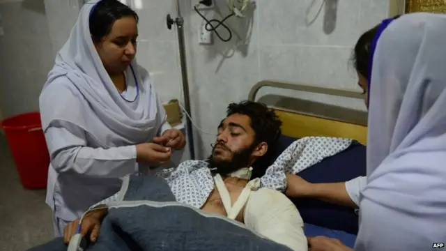 Health workers treat an injured man in Peshawar's hospital