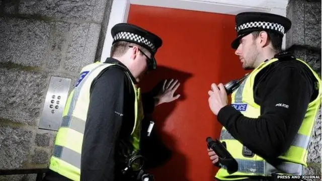 Two police officers at a door