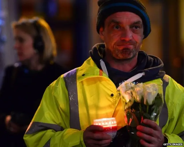 Man leaves flowers in George Square