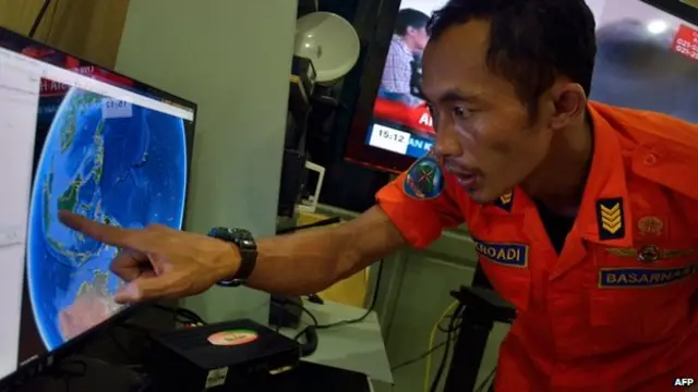 An official from Indonesia's national search and rescue agency in Medan, North Sumatra points at his computer screen to the position where AirAsia flight QZ8501 went missing off the waters of Indonesia on 28 December, 2014