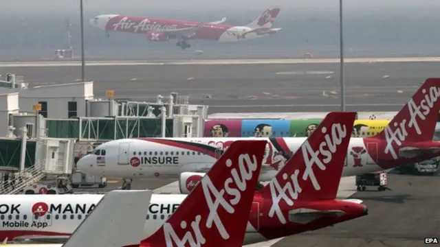 An Air Asia aircraft lands behind other Air Asia jets, at Kuala Lumpur International Airport 2 terminal (KLIA 2) in Sepang, outside Kuala Lumpur, Malaysia on 24 June 2014