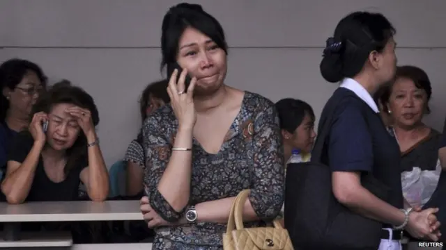 Family members of passengers on board AirAsia flight QZ8501 wait for information inside the AirAsia crisis centre at Juanda Airport in Surabaya, East Java on 28 December 2014