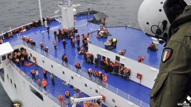 Member of Italian navy looking down at passengers on ferry