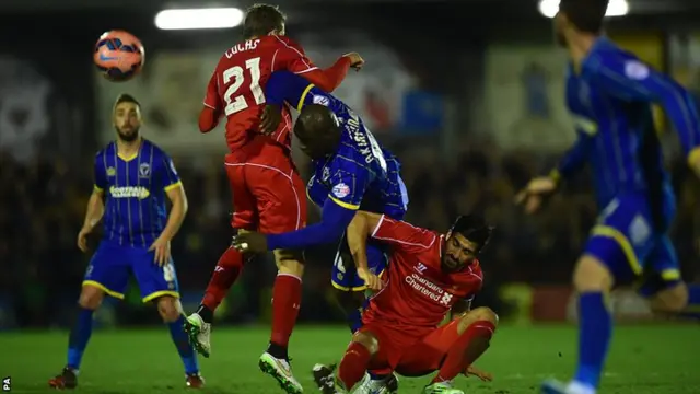 AFC Wimbledon and Liverpool battle for the ball