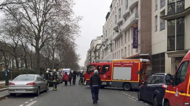 Firefighters and rescue services gather near the Hebdo offices