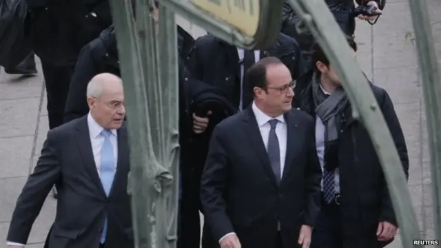 French President Francois Hollande (R) arrives at the Paris offices of Charlie Hebdo