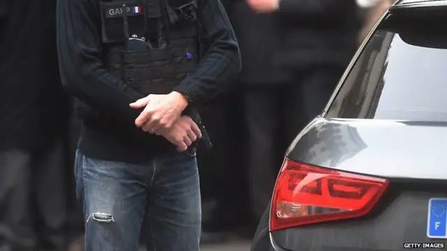 Police officers gather in front of the offices of the French satirical newspaper Charlie Hebdo