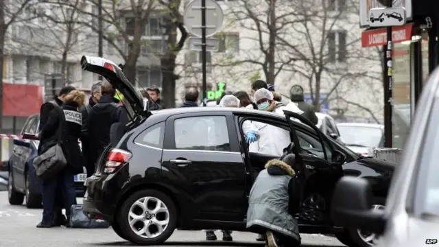 French police officers and forensic experts examine the car used by armed gunmen who stormed the Paris offices of satirical newspaper Charlie Hebdo