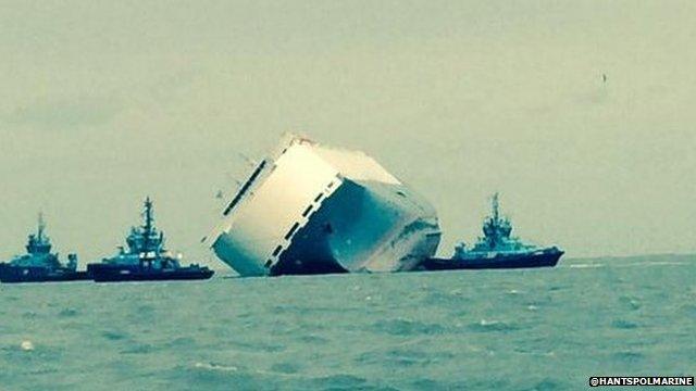 Three tugs tow the vessel