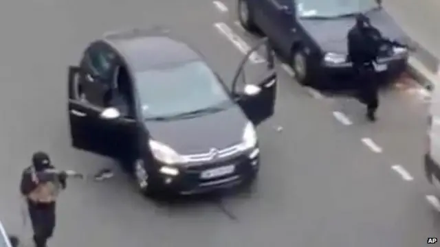 Masked gunman fire their weapons outside the French satirical newspaper Charlie Hebdo's office, in Paris, on 7 January 2015.