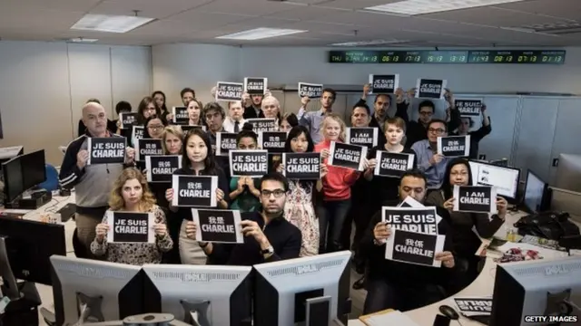 Staff members of Agence France-Presse display placards in solidarity with the victims of the shooting at the Paris office of the satirical newspaper Charlie Hebdo