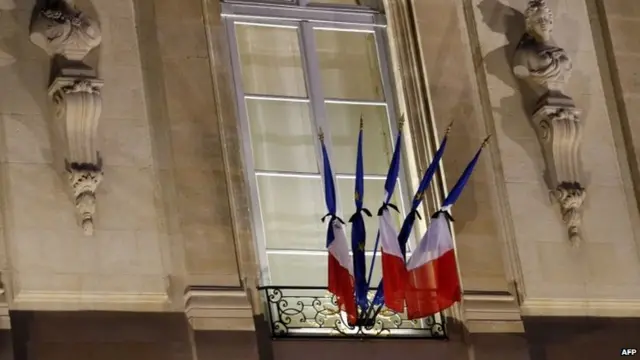 French flags are tied with black ribbons at the Elysee Palace