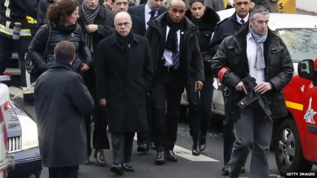 French Interior Minister Bernard Cazeneuve walks at the site of a shooting in Montrouge, south of Paris