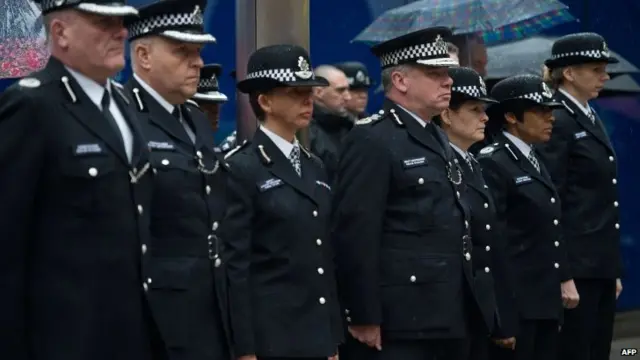 Deputy Commissioner of Britain's Metropolitan Police Craig Mackey (4th L) leads police officers in a two minute silence outside Scotland Yard in London, on January 8, 2015.