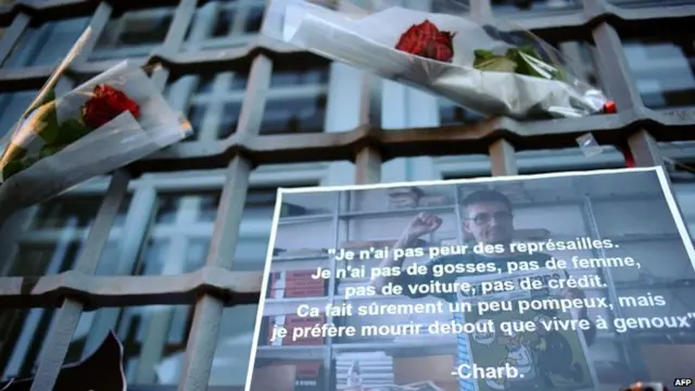 A picture taken on January 8, 2015 in front of the city hall in Toulouse shows a picture of late French cartoonist and editor in chief of French satirical newspaper Charlie Hebdo,