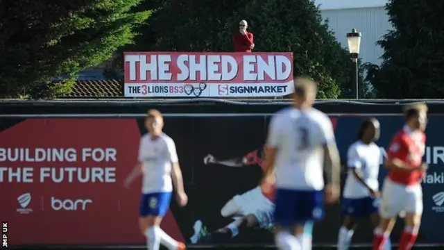 Bristol City fan Ben Swift watches a game from his shed roof