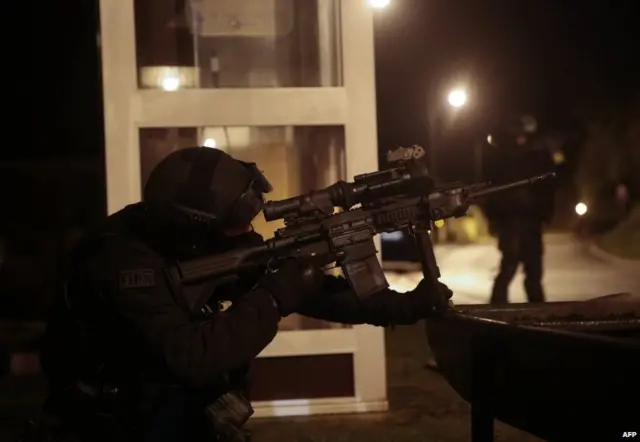 A member of the French police intervention force (FIPN) looks through the scope of his rifle as during searches in Fleury, northern France, on January 8, 2015