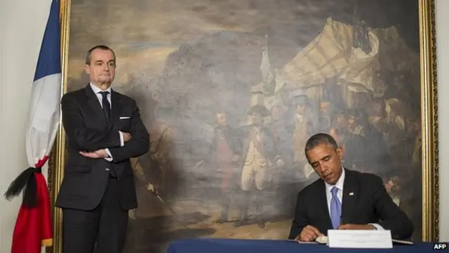 US President Barack Obama (R) signs the condolence book beside French ambassador to the United States Gerard Araud (L) in Washington, DC, January 8