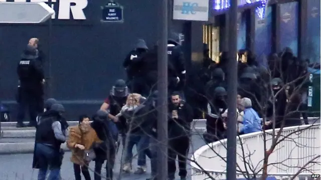 Members of the French police special forces evacuate the hostages after launching the assault at a kosher grocery store in Porte de Vincennes, eastern Paris, on 9 January 2015