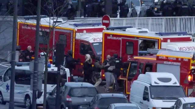 A security officer directs released hostages after they stormed a kosher market to end a hostage situation, Paris, on 9 January 2015.