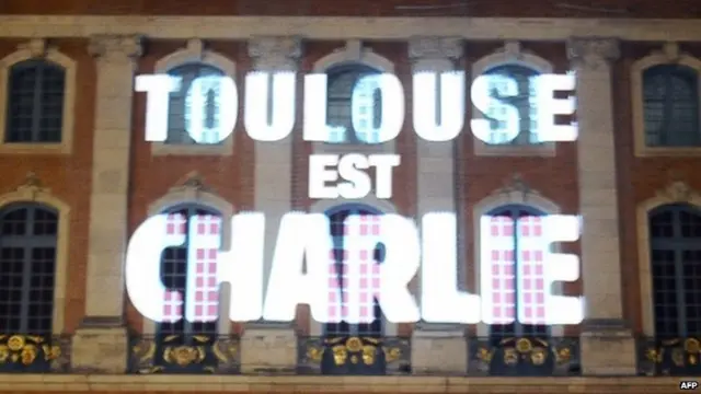 A sign reading "Toulouse est Charlie" the side of a building