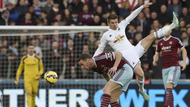 Swansea's Tom Carroll clashes with West Ham captain Kevin Nolan
