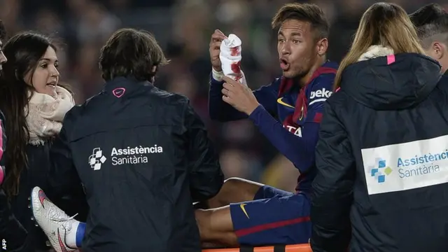 Neymar Jr holds up a bloodied sock