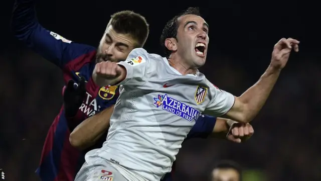 Barcelona's Gerard Pique and Atletico's Diego Godin go for the ball