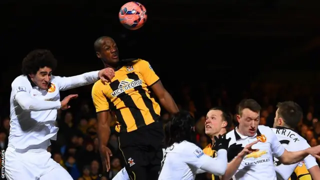 Tom Elliott of Cambridge United goes up for a corner
