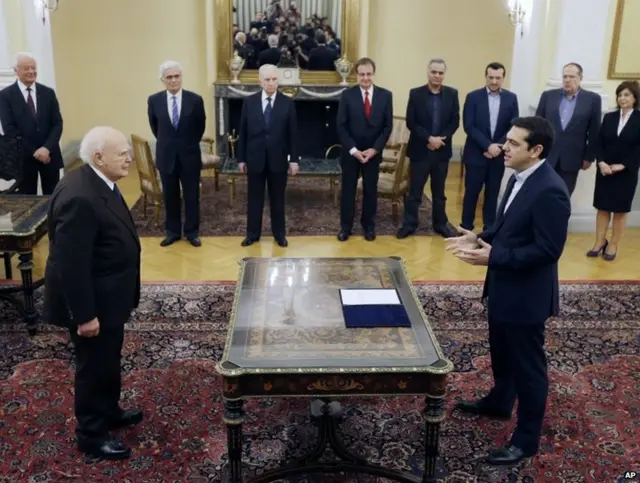 Greece"s Prime Minister Alexis Tsipras, right, takes a secular oath to the Greek President Karolos Papoulias at the Presidential Palace in Athens