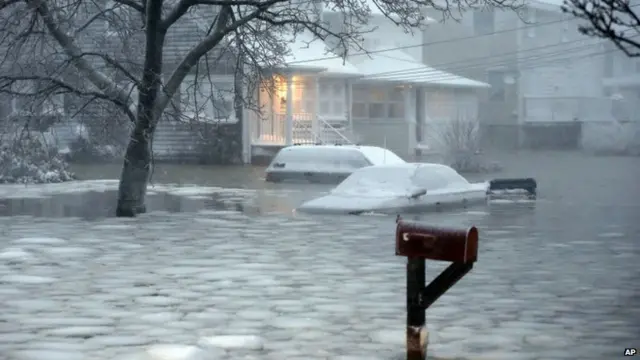 Water floods a street on the coast in Scituate, Massachusetts 27 January 2015