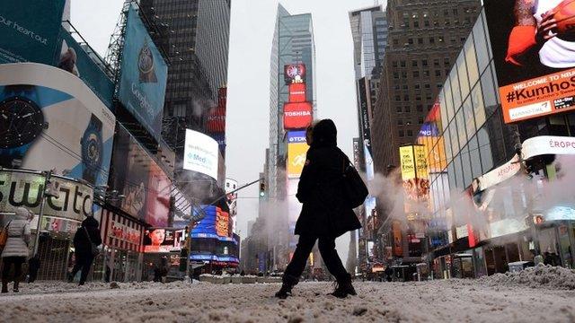 A few tourists wonder around nearly deserted New York"s Times Square what is normally a crowed morning rush hour