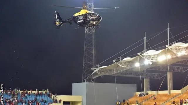 A police helicopter hovers over the stadium