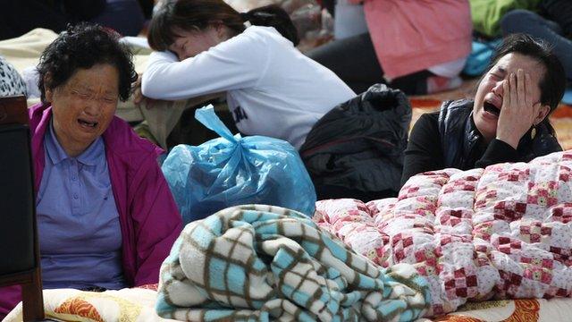 Relatives of missing passengers aboard the sunken ferry Sewol cry on 20 April 2014