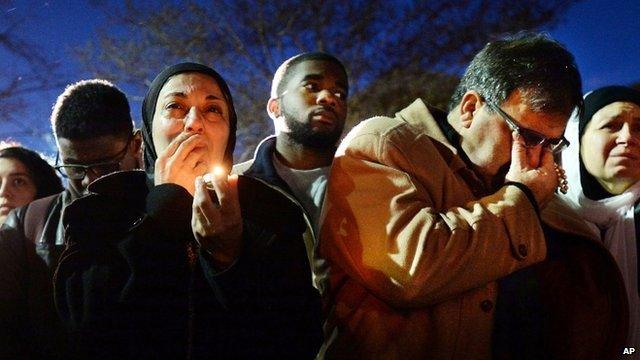 Namee Barakat, right, wipes away tears as he and his wife, Layla, left, watch photos projected on a screen during a vigil for his son, daughter-in-law and her sister, who were killed at a condominium near UNC-Chapel Hill. 11 February 2015,