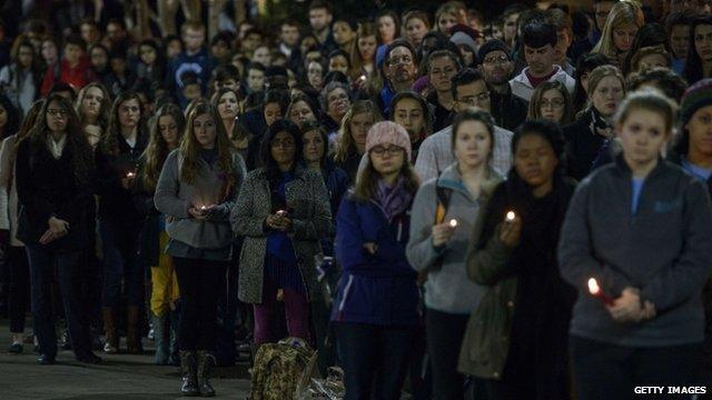 People listen during a vigil at the University of North Carolina following the murders of three Muslim students on 11 February 2015