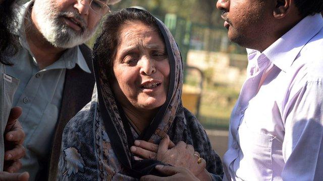 Pakistani relatives comfort a resident following an attack by Taliban militants on a Shiite Muslim mosque in Peshawar on 13 February 2015