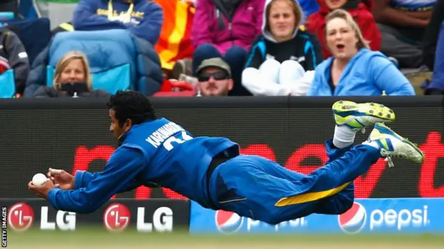 Dimuth Karaunaratne dives full-length to take a catch