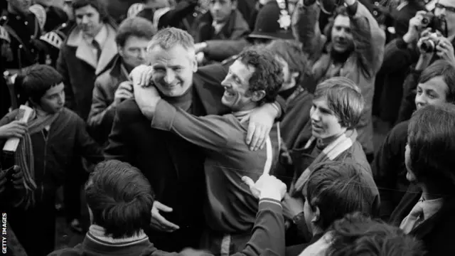 Colchester United's manager Dick Graham is embraced by winger Brian Gibbs