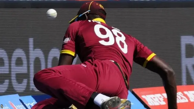 Jason Holder slides for the ball