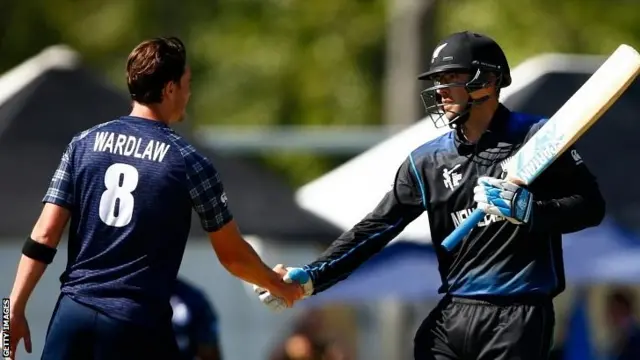 Daniel Vettori of New Zealand (R) shakes hands with Iain Wardlaw