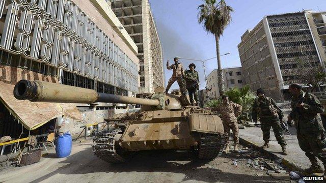 Members of the Libyan pro-government forces, backed by locals, gather on a tank outside the Central Bank, near Benghazi port, 21 January 2015