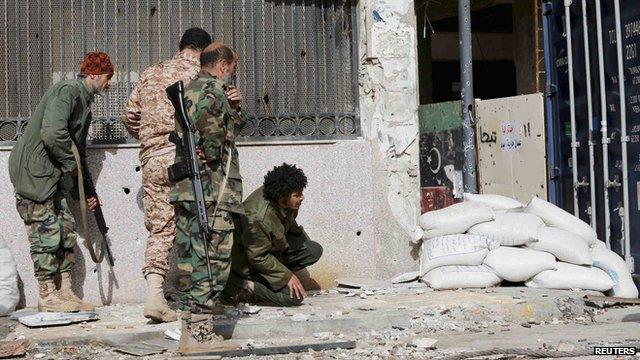 Members of the Libyan pro-government forces, backed by locals, take up positions during clashes with militants on 21 January 2015