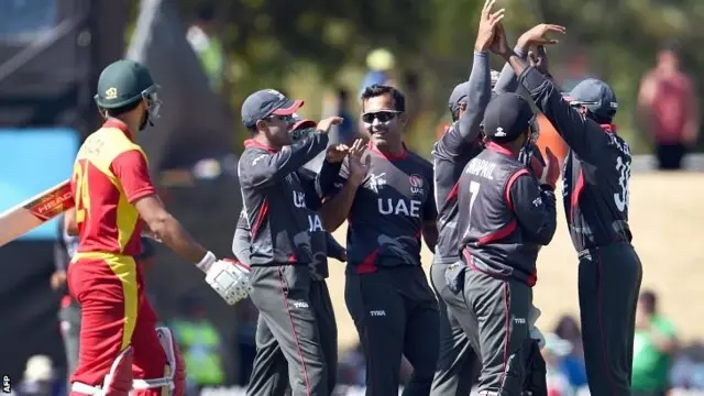 United Arab Emirates (UAE) bowler Mohammad Tauqir (C) celebrates with teammates after dismissing Zimbabwe batsman Sikandar Raza