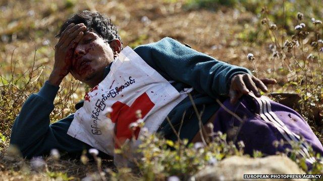 A wounded Red Cross volunteer lies on ground after vehicles of a rescue convoy were attacked in the Kokang region on 17 February 2015