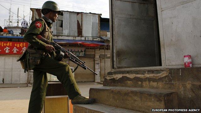 Armed military soldier takes position at the corner of a street in Laukkai, Myanmar on 16 February 2015