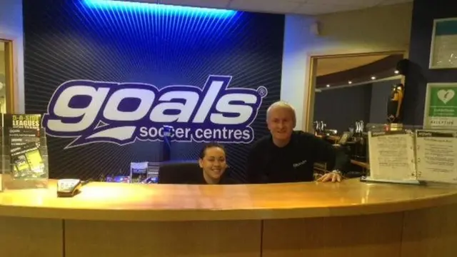 Two staff at reception in Goals Chingford