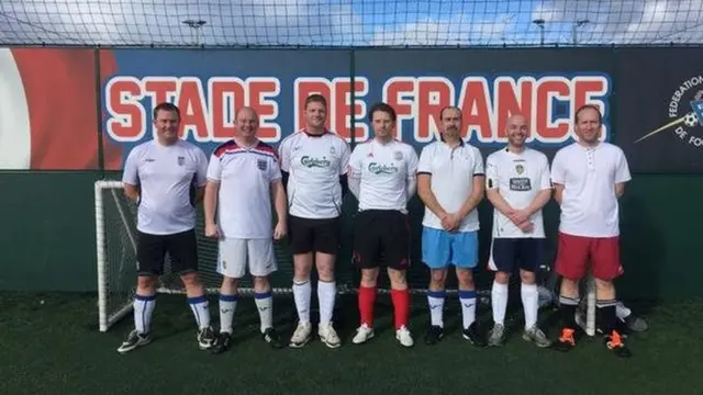 5-a-side team in front of a Stade de France banner